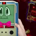 PortaBoy+ handheld console next to creepy monster